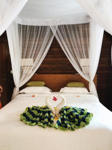 蓝梦岛达尔桑蓝梦精品小屋旅馆的一间卧室配有一张带心形毯子的床