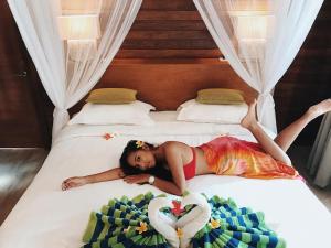 蓝梦岛达尔桑蓝梦精品小屋旅馆的躺在床上的女孩,有心毯