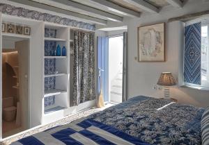 TripótamosXinara House的蓝色和白色的卧室设有床和窗户