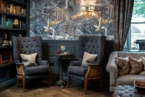 比德内尔Beadnell Towers Hotel的客厅配有两把椅子和壁画