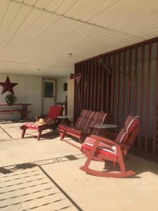 埃斯卡兰特Dora's Country Cottage的坐在门廊上的一群红色长椅