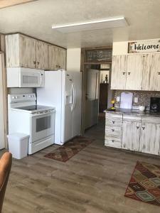 埃斯卡兰特Dora's Country Cottage的厨房配有白色家电和木制橱柜