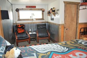 埃斯卡兰特牛仔乡村酒店的一间卧室配有一张床、两把椅子和一个窗户