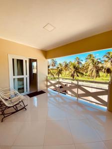 弗雷谢拉斯Casa em flecheiras com piscina的客房设有一个享有棕榈树美景的阳台。