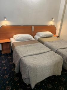 巴黎自由酒店的酒店客房设有两张床和一张桌子。