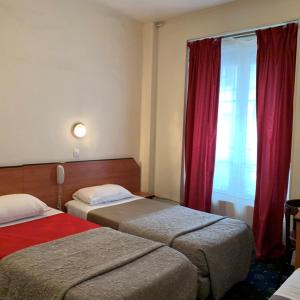 巴黎自由酒店的酒店客房设有两张床和窗户。