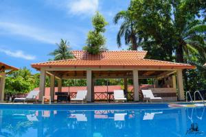 海地角卡纳别墅酒店的游泳池旁设有凉亭和椅子