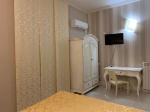 萨尔扎纳阿尔伯哥拉维勒塔酒店的一间卧室配有一张床、一张书桌和一台电视。