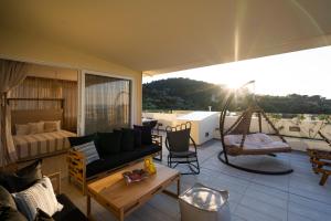 罗希姆诺Helen Luxury Holiday House with Sea View的客厅配有沙发,阳台上设有吊床。