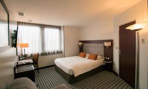 里摩日Kyriad Limoges Centre Gare - Atrium的酒店客房设有床和窗户。