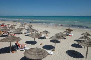 塔格梅斯Iris Hotel & Thalasso的海滩上有许多遮阳伞和人