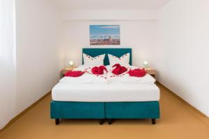 慕尼黑Hotel Ludwig的蓝色和白色的床,上面有红玫瑰
