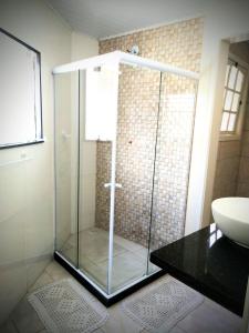 特雷索波利斯Hospedagem Doce Lar - Casa Manacá的一个带水槽的玻璃淋浴间