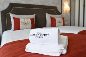 里斯本Famous Crows Lisbon Suites的一间酒店客房,床上有一堆毛巾