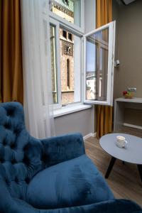 萨拉热窝Beys Palace apartments Sarajevo的窗户客房内的蓝色椅子和桌子