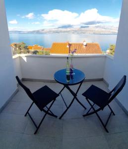 斯普利特卡Villa Marija的阳台配有桌椅,享有水景
