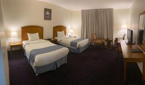 阿可贺巴Doolve Hotel Al Khobar的酒店客房配有两张床和一张书桌