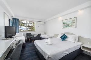 纽卡斯尔Alloggio Newcastle Beach的酒店客房设有两张床和电视。