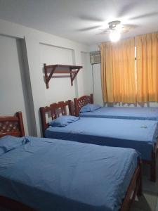 洛斯拉甘斯Hospedaje Paraiso Norteño的一间卧室设有两张床和窗户。