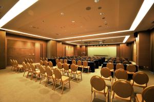 台南Academy Hotel的一间会议室,里面摆放着一排椅子和屏幕