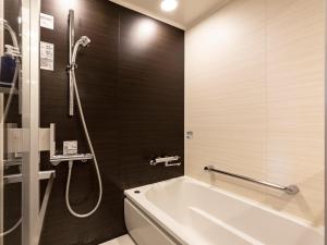 鹿儿岛鹿儿岛索拉瑞亚西铁酒店的设有带浴缸和淋浴的浴室。