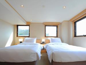 ShimotakaiT Hotel Ryuoo的带2扇窗户的客房内的2张床