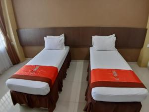 万隆Hotel Bumi Makmur Indah的两张睡床彼此相邻,位于一个房间里