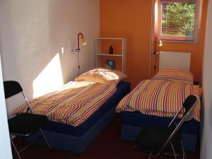 弗里斯特Ferienwohnung Welle的一间卧室配有两张床和两把椅子