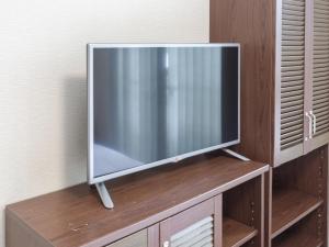 米子市Tabist International Hotel Kaike的木制橱柜顶部的平面电视