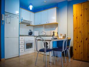 卡耐特蒂贝兰格Apartment Segrelles by Interhome的厨房拥有蓝色的墙壁和白色的橱柜,配有桌椅