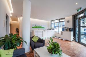 慕尼黑拜尔公寓式酒店的开放式客厅(带植物)和厨房