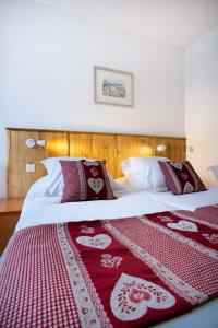 伊斯内姆Hotel Relais d'ISSENHEIM Table d'hôtes的一间卧室配有两张带红白毯子的床