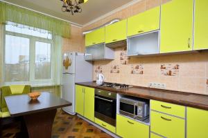 鄂木斯克Apartment Karla Marksa 22的厨房配有黄色橱柜和桌子