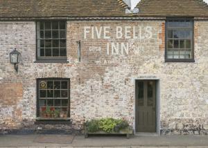 BrabourneThe Five Bells Inn的一座砖砌建筑,上面有读五球的标志