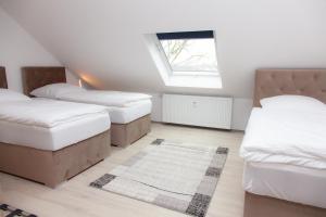 杜伊斯堡T&K Apartments near Messe Fair Trade Düsseldorf und Airport 3B的阁楼卧室设有两张床和窗户。