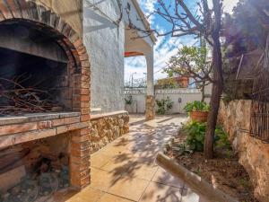托里代巴拉Holiday Home Gavina by Interhome的室外庭院设有砖砌壁炉和树