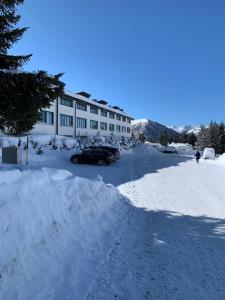 塞斯特雷Nice house on the ski slopes的大楼前的雪地停车场