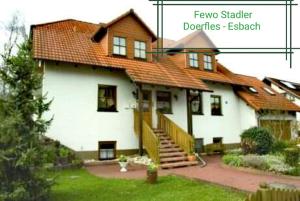 NeudörflesStadler Ferienwohnung的一座大型白色房屋,设有红色屋顶