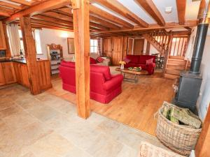 哈佛威斯特Cowslip Cottage的客厅配有红色沙发和炉灶