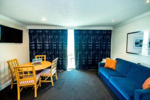 威尔伍德克拉斯特皇家港口海滨酒店的客厅配有蓝色的沙发和桌子