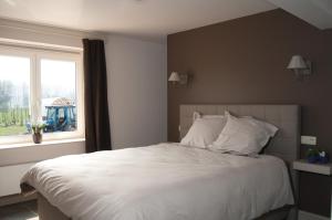Hoeselt福鲁托夫住宿加早餐旅馆的卧室配有一张大白色床和窗户