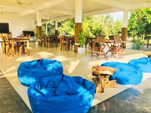 锡吉里亚Into The Wild Sigiriya的一间设有蓝色椅子和桌椅的房间