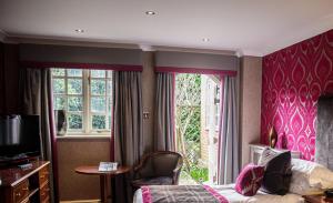 霍利Langshott Manor - Luxury Hotel Gatwick的酒店客房设有床和窗户。