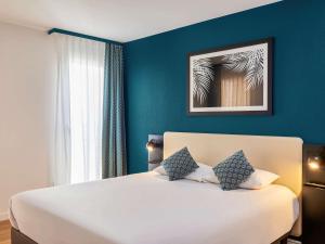 博索莱伊摩纳哥约瑟芬宫阿德吉奥公寓式酒店的卧室配有白色大床和蓝色的墙壁