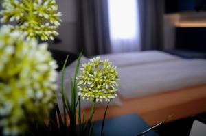 萨尔茨堡Pension Elisabeth - Rooms & Apartments的一张带鲜花的桌子和一张床