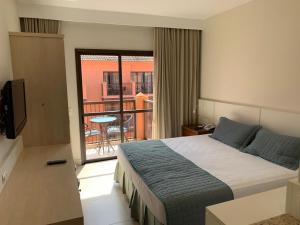 弗洛里亚诺波利斯Jurerê Beach Village - Flat na Praia的酒店客房设有一张床和一个阳台。