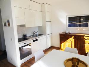 BrioneCasa Marco的白色的厨房配有白色的橱柜和桌子