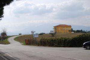 奥菲达Residence Borgo Offida的通往山坡上黄色房子的道路