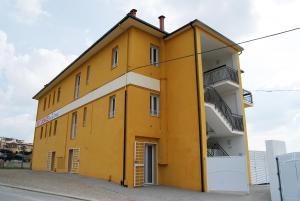 奥菲达Residence Borgo Offida的黄色的建筑,旁边设有阳台