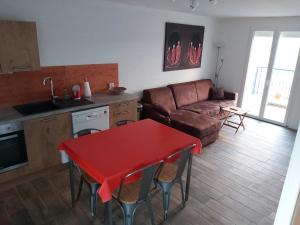 Sarrasles vignes Ardéchoises - Peuplier的客厅配有红色桌子和沙发